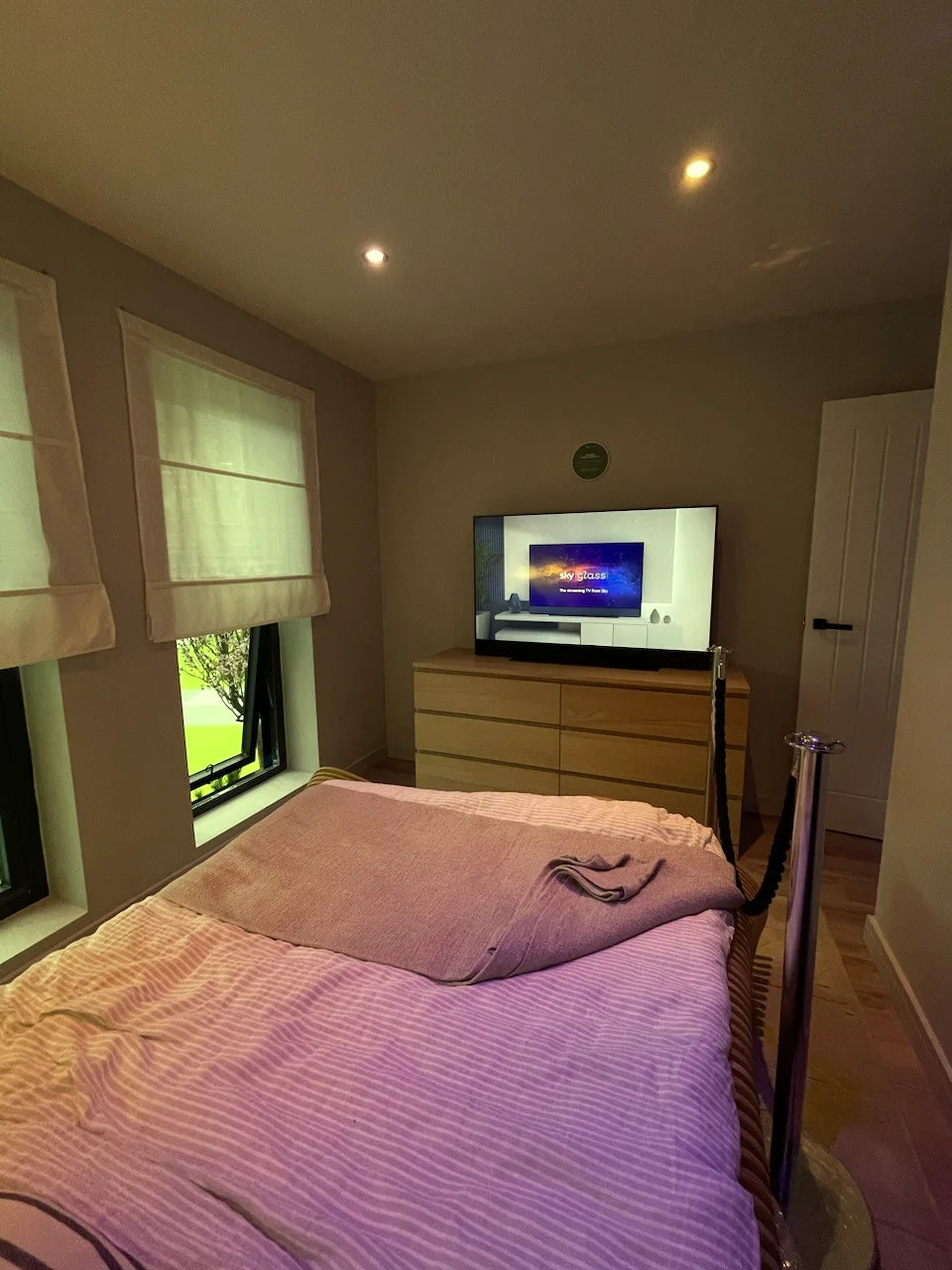 First-floor bedroom with double bed, chest of drawers, wall-mounted television and window blinds